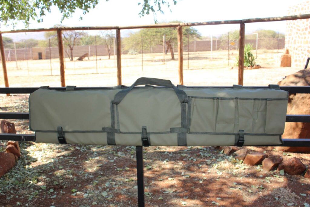 Cattle rail gun bag strapped to a rail in a game camp